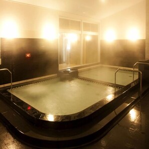 A hot tub with a glass enclosure, surrounded by walls with a reflective surface. - Sauna & Cupsule Cure Kokubuncho (Sendai)