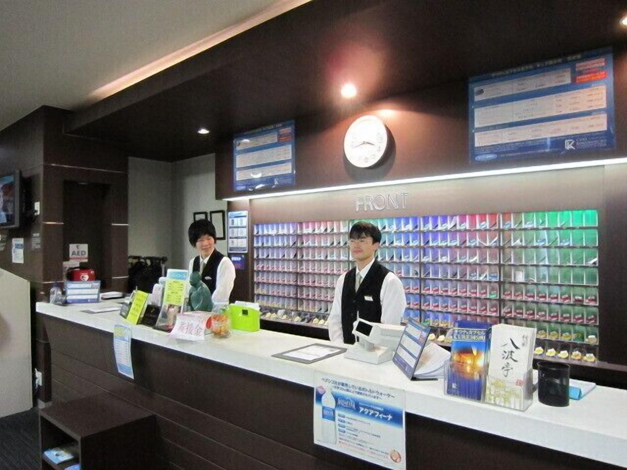 A reception desk with a clock, informational signs, and a display of products.