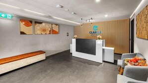 Un espace d’accueil au design moderne, comprenant un comptoir d’accueil, un espace détente et un panneau mural.