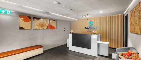 A reception area with a modern design, including a reception desk, seating area, and a wall-mounted sign.