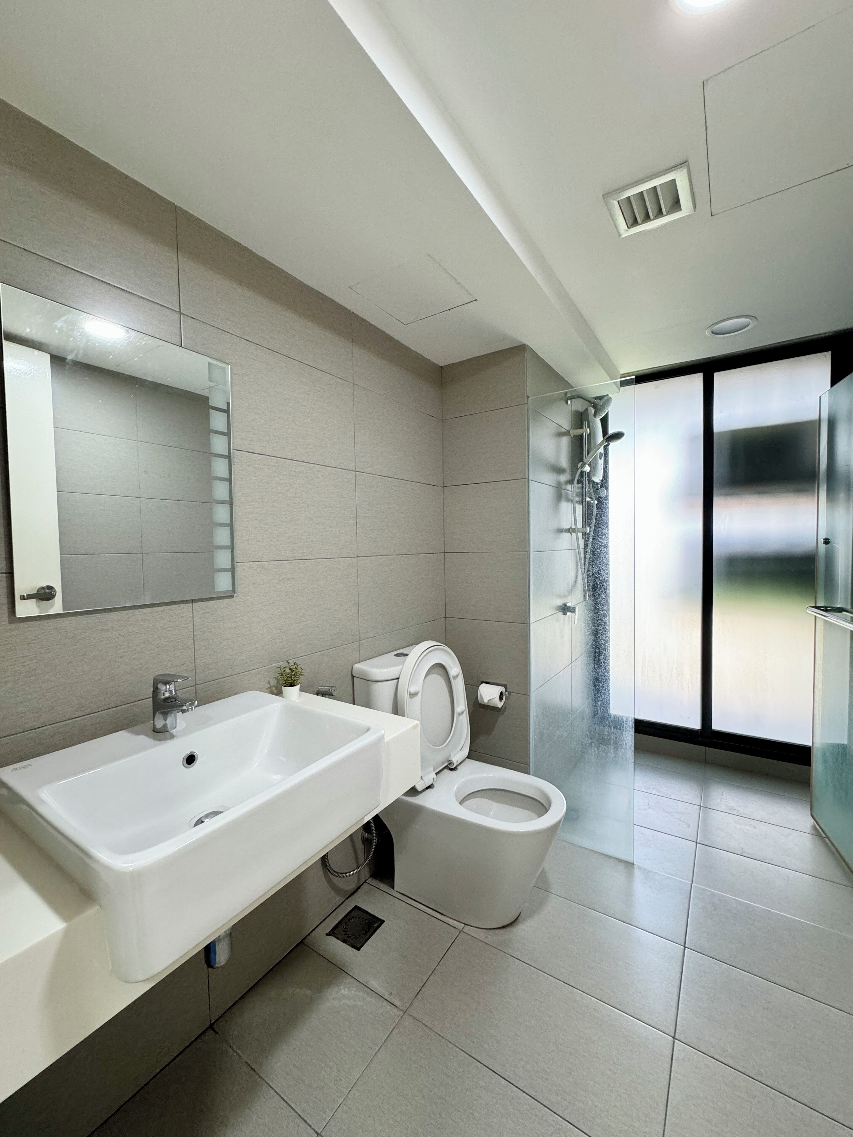 A modern bathroom with a large sink, toilet, and shower.