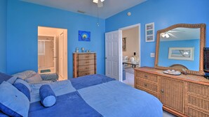 Quarto com cama, penteadeira e ventoinha no teto.
