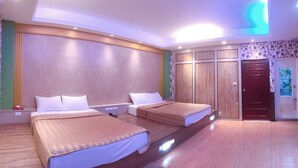 Une chambre d’hôtel avec deux lits, des lambris en bois sur les murs, un plancher en bois et une porte ornée d’un vitrail coloré.