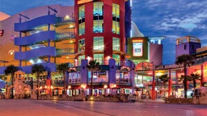 A multi-story hotel with a prominent red and yellow facade, multiple balconies, and outdoor seating areas.