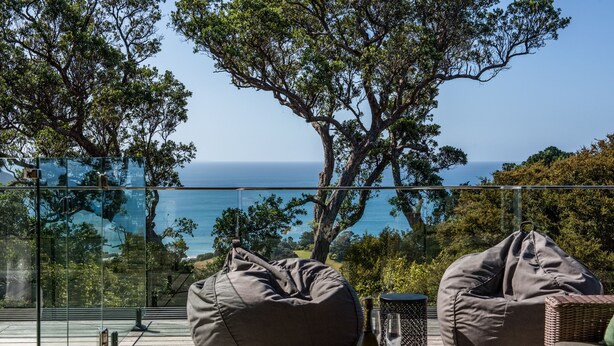 A glass-enclosed deck with two bean bags and a glass table, overlooking a scenic ocean view. - Onetangi Oasis - fabulous home with pool & great views! (Onetangi)