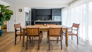 A modern kitchen with dark cabinets, a wooden dining table, and six woven chairs. - Onetangi Oasis - fabulous home with pool & great views! (Onetangi)