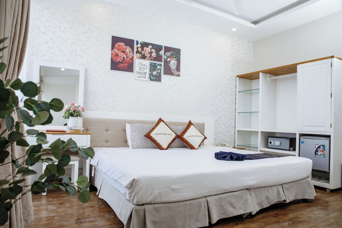 Ein ordentlich eingerichtetes Schlafzimmer mit Bett, Nachttisch, Spiegel und Kleiderschrank.