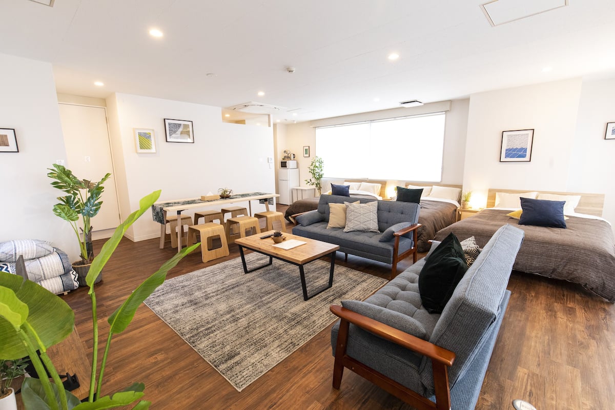 Una sala moderna con sofá, sillón, mesa de centro y un comedor con sillas y mesa.