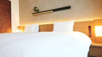 A hotel room with a large bed, wooden headboard, bedside lamps, and a wall-mounted light fixture.