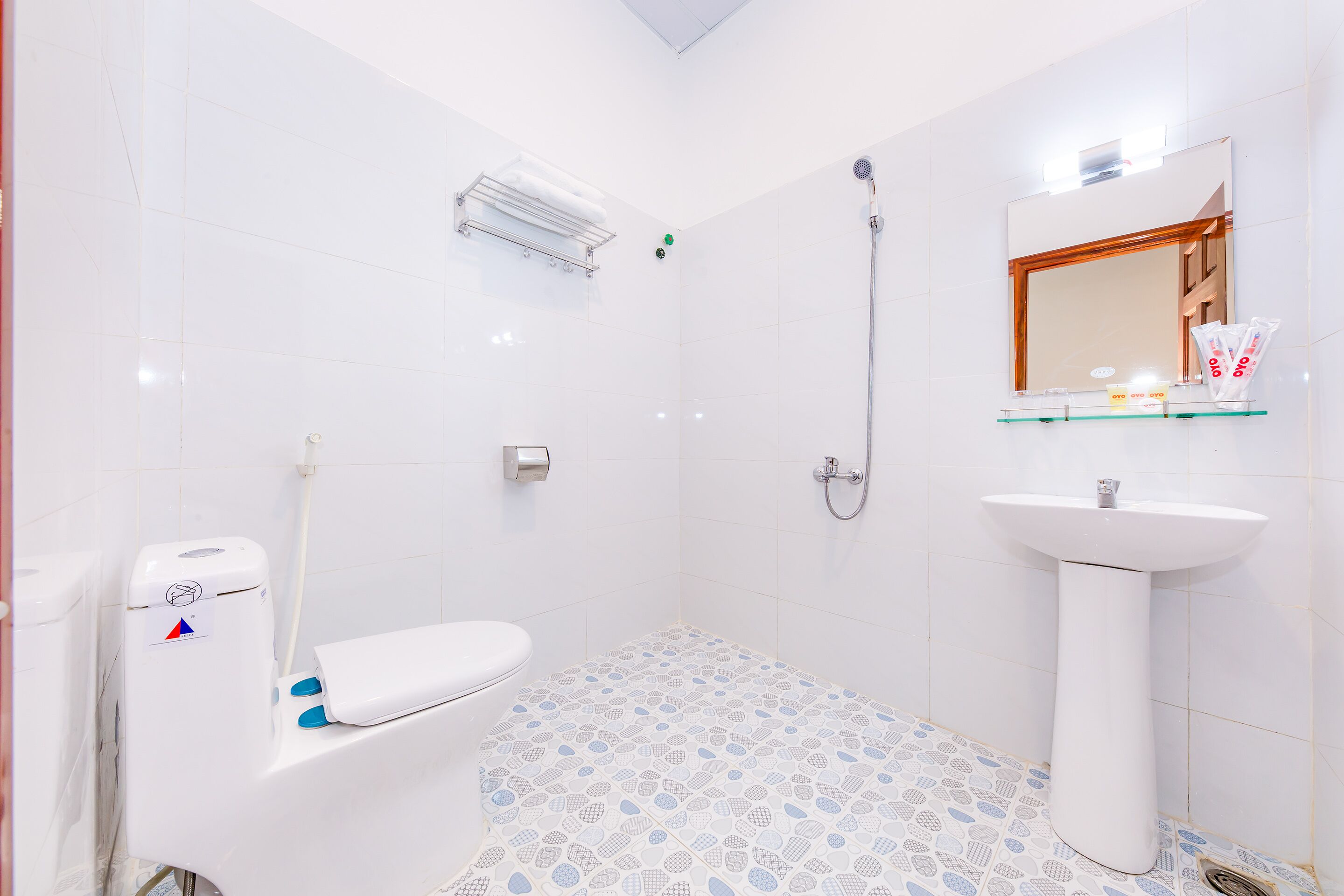 Un baño con inodoro, lavamanos, ducha y espejo.