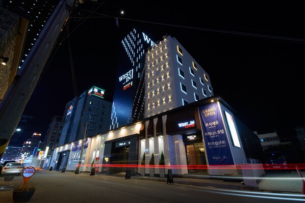 A hotel with a prominent 'Westin' sign, multiple floors, and a large illuminated advertisement for the 'Grand Opening' of a coffee shop. - West In Hotel (Yeosu)