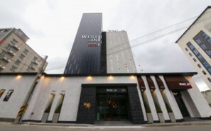 A hotel with a modern facade, featuring a prominent vertical sign with the name 'WESTIN HOTEL'. - West In Hotel (Yeosu)