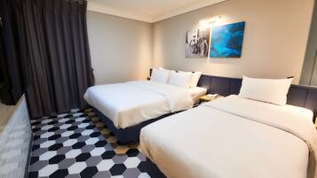 A hotel room with two beds, a large window with curtains, a wall-mounted artwork, and a geometric patterned floor.
