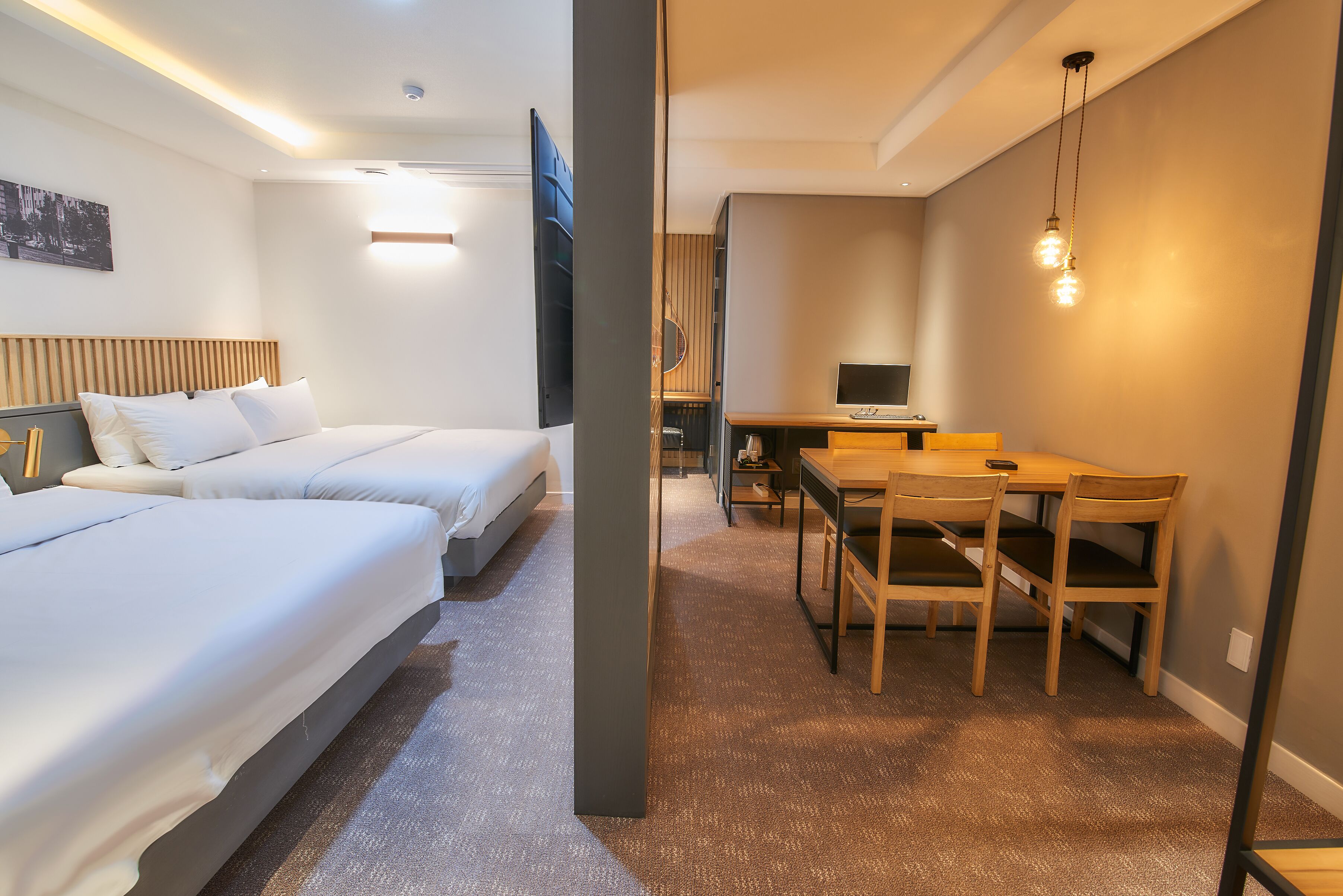 Habitación de hotel con dos camas, un escritorio y una mesa de comedor.