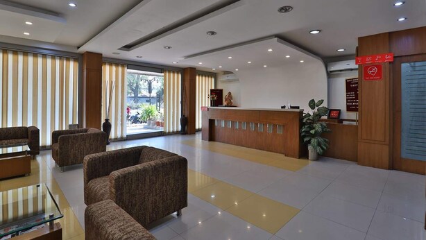 Una hall d'albergo con reception, area salotto e vista sull'esterno.