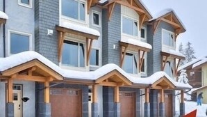 A multi-story house with a skiway leading to the entrance. - Cozy Ski-In/Ski-Out Escape: 3BR Echo Landing Home Near Orient Chairlift Sleeps 7 (Sun Peaks)