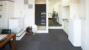 A hotel room with a kitchenette, a dining area, and a mirror. - Sakamoto Building 6F (Osaka)