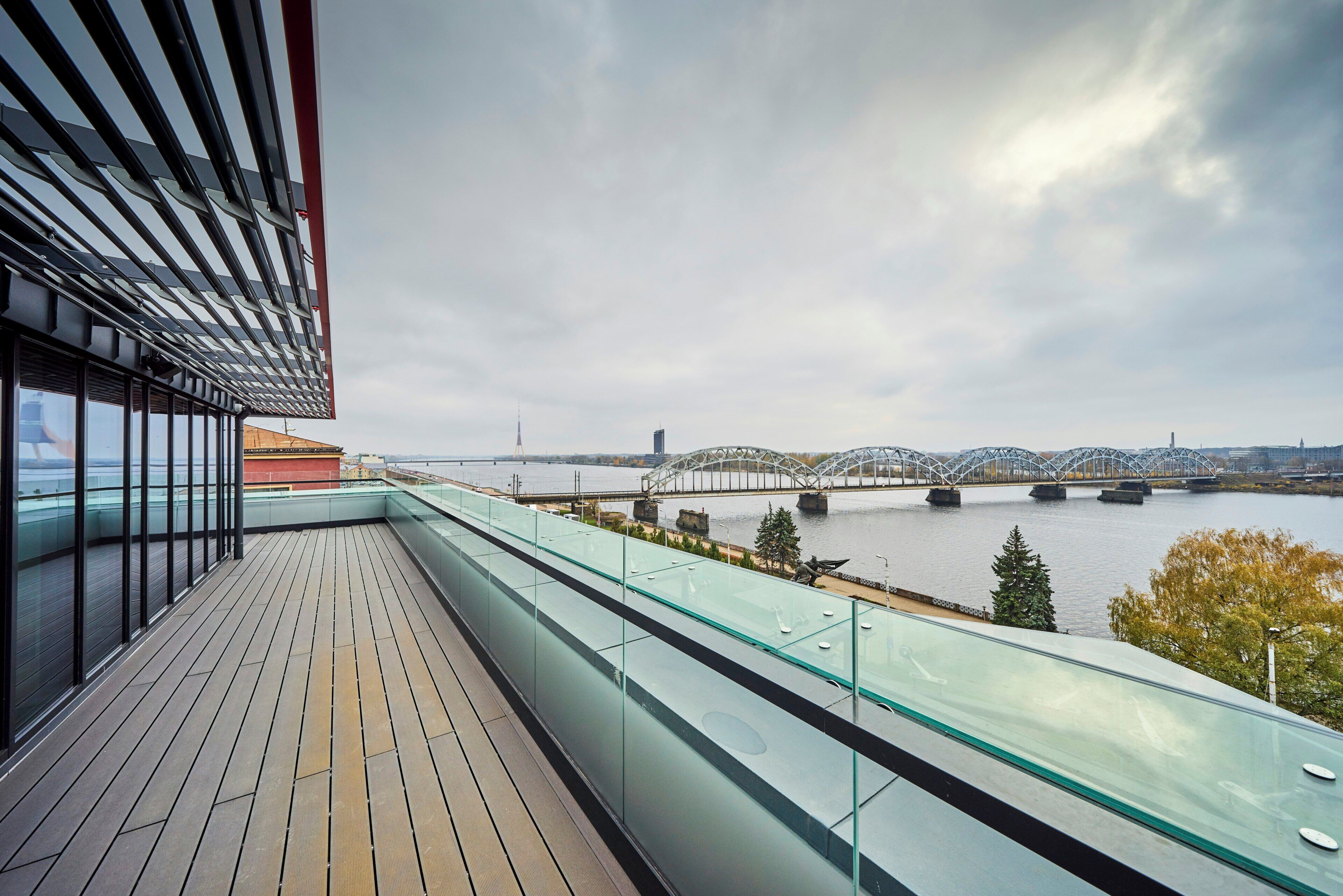 A modern balcony with a view of a river and bridges.