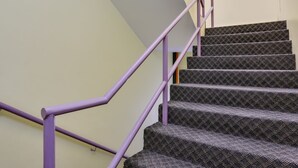A staircase with purple railings and patterned carpet. - OYO 89583 Grove Hotel (Kajang)