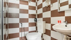 Ein Badezimmer mit Schachbrettfliesen, einer Toilette, einem Waschbecken und einer Dusche.