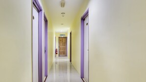 A hallway with purple-framed doors, a fire extinguisher, and a sign reading "KELUAR". - OYO 89583 Grove Hotel (Kajang)