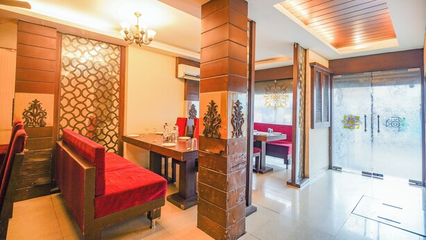 Un vestíbulo de hotel con mostrador de recepción, zona de estar y una escalera.
