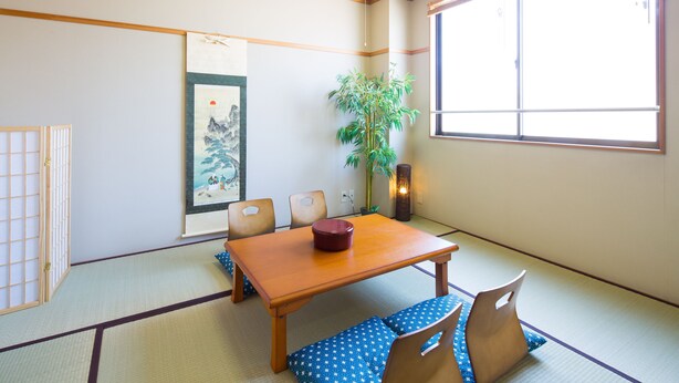 A traditional Japanese room with tatami flooring, a low wooden table, and a large window. - Sakamoto Building 7F (Osaka)