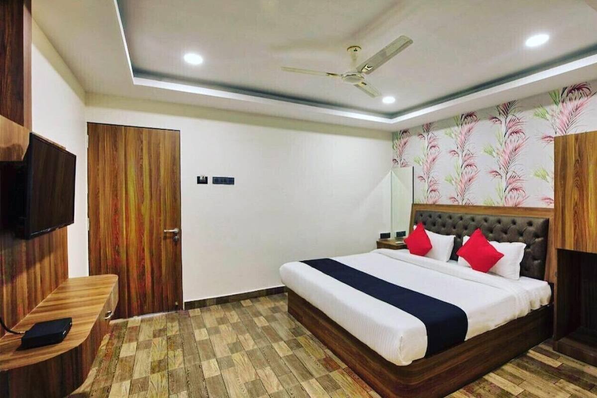 Une chambre d’hôtel équipée d’un lit, d’une télévision, d’un bureau et d’un ventilateur de plafond.