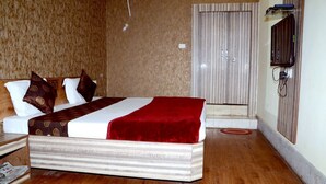 Ein Hotelzimmer mit einem Bett, einem Fernseher und einer Tür.