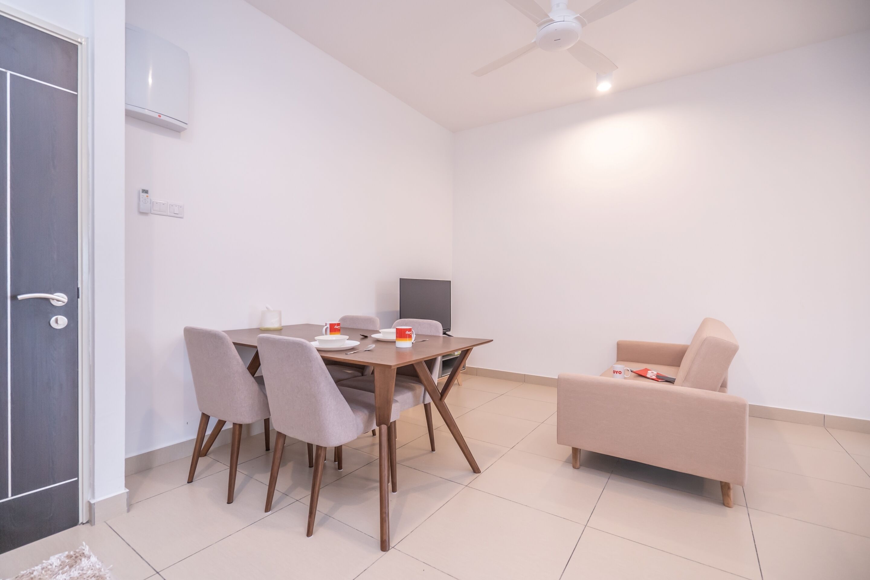 A modern living room with a dining table, chairs, a sofa, a TV, and a ceiling fan.