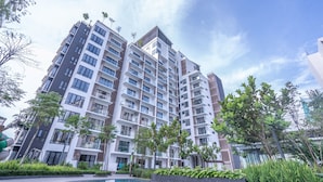 A high-rise residential building with multiple balconies, a swimming pool, and surrounding greenery. - OYOHome 89448 Extraordinary Studio (Genting Highlands)