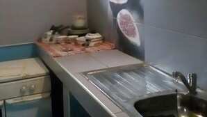 A kitchen with a window, a sink, and a countertop with various items. - Apartment F2 secure city center (Antisiranana)