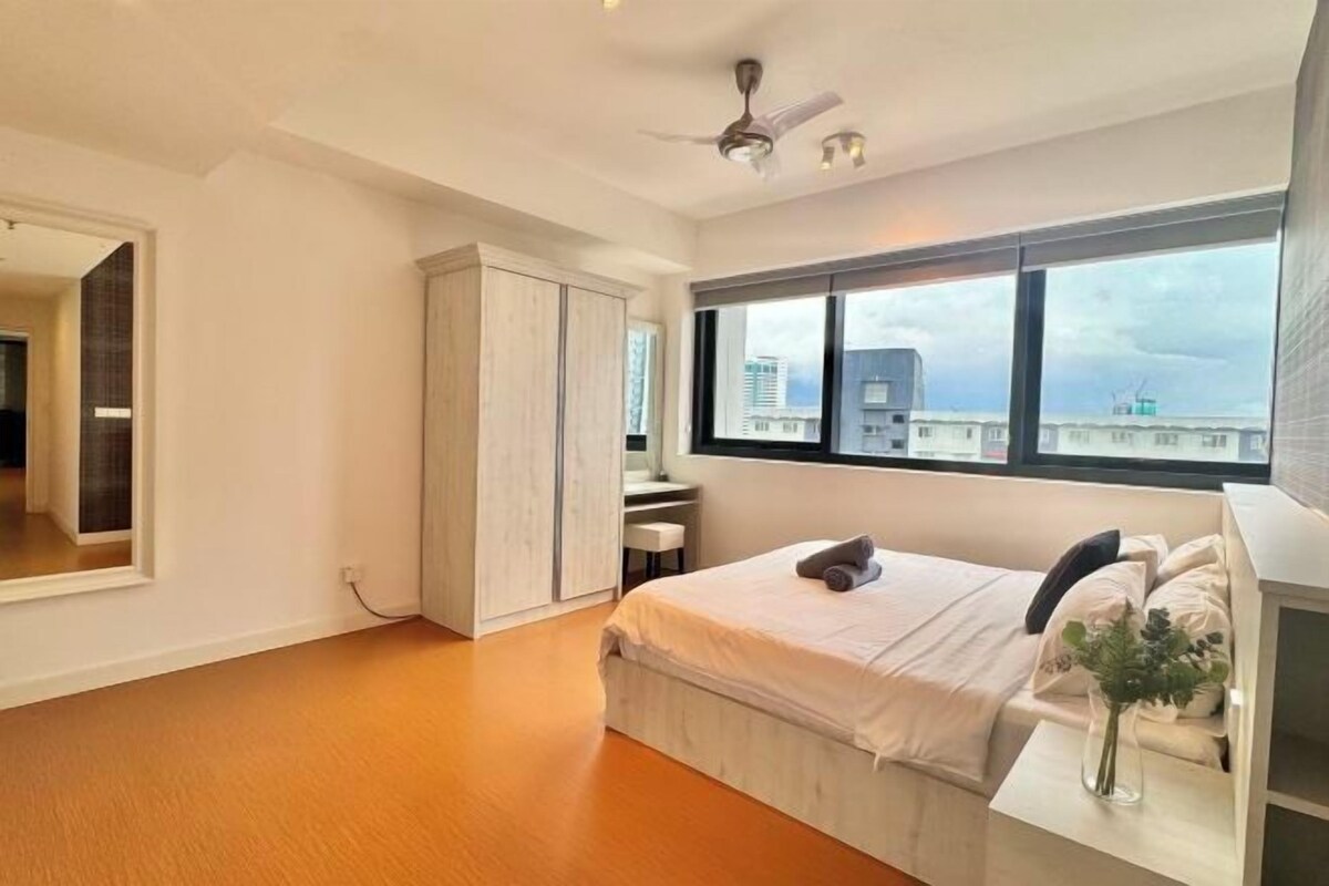 A bedroom with a bed, a vanity, a wardrobe, a window with a view, and a ceiling fan.