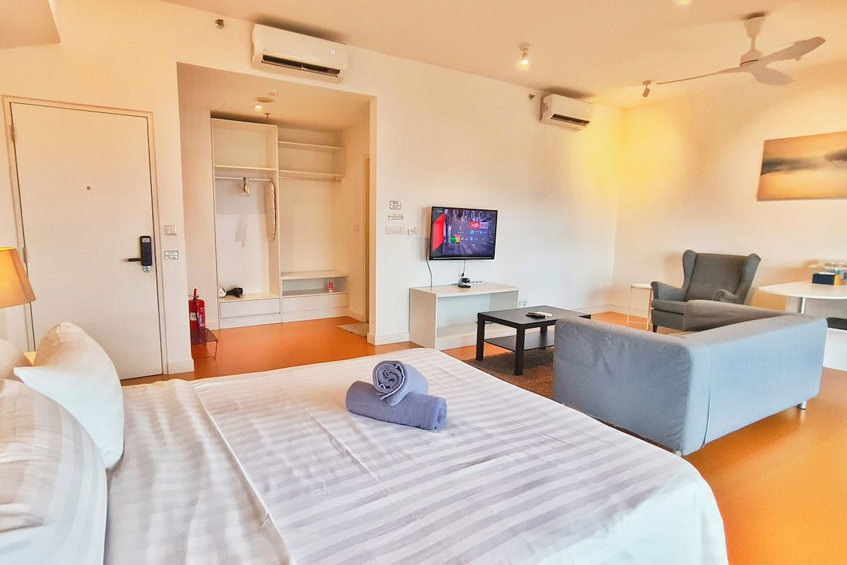Une chambre d’hôtel équipée d’un lit, d’un bureau, d’une chaise, d’une télévision et d’un appareil de climatisation.