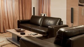 A modern living room with a leather sofa, a coffee table, and a flat-screen TV. - Dorobanti 11 - 2 bedroom apartment (Sector 1)