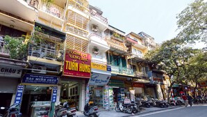 A street with various shops and a hotel named 'The Sinh Tourist'. - OYO 604 Queen Hotel (Hanoi)