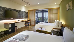 Een hotelkamer met een bed, een bureau, een stoel, een televisie en uitzicht op de omgeving.