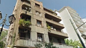 Um edifício de vários andares com varandas, algumas com plantas.