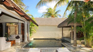 A pool area with lounge chairs, a covered seating area, and palm trees. - Villa Oasis 1 no 7 (Grand-Baie)