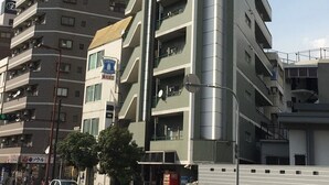 Un edificio de varios pisos con un llamativo letrero de H2O Total Care House.