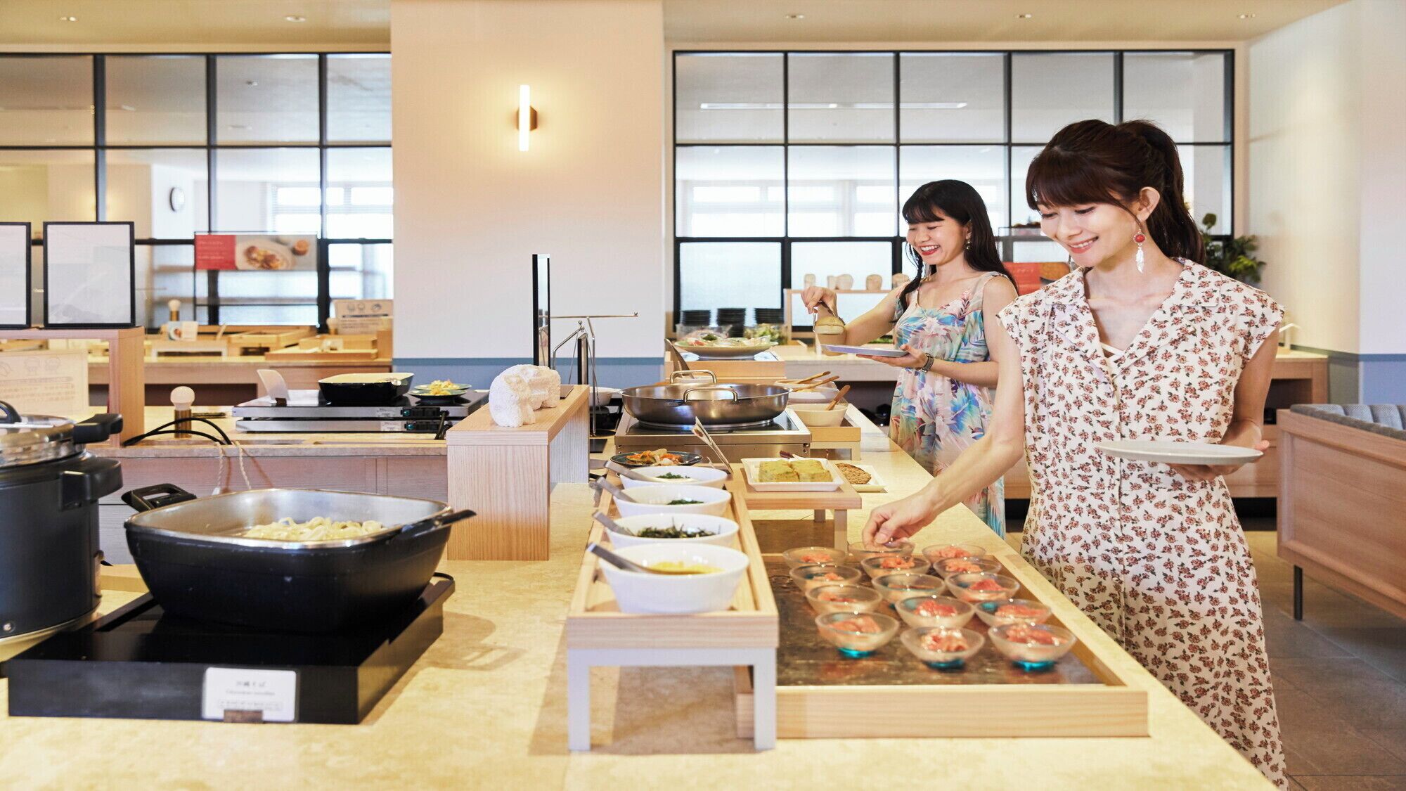 A buffet setup with various dishes and cooking equipment.