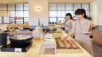 A buffet setup with various dishes and cooking equipment.
