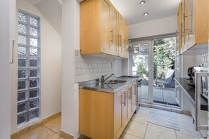 Enjoy cooking in this well-equipped kitchen with a sink and window overlooking lush surroundings.