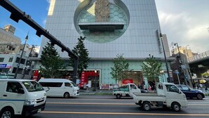 Un edificio moderno con un diseño arquitectónico único, que presenta una escultura grande y central.
