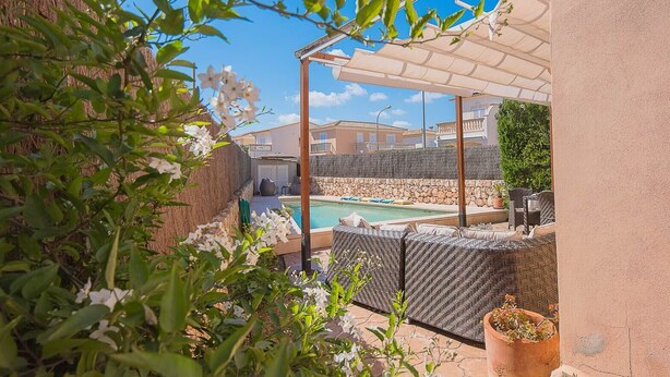 A private pool area with a pergola, outdoor furniture, and a stone wall. - Villa Sebastian in Sa Rapita, close from the sea. (Sa Ràpita)
