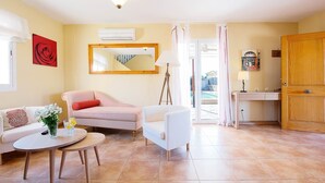 A living room with a sofa, armchair, coffee table, and a painting of a rose. - Villa Sebastian in Sa Rapita, close from the sea. (Sa Ràpita)