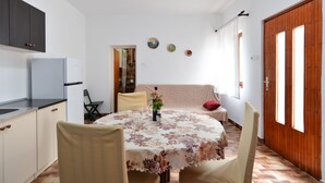 A compact living space with a kitchen, dining area, and a sofa.