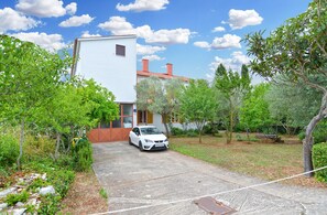 Stunning two-story home with a lush garden and driveway.