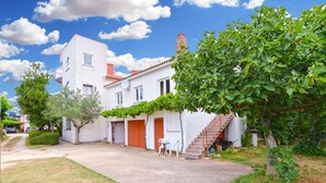 A two-story white house with a red roof, a covered patio with outdoor furniture, and a staircase leading to the upper floor. - Apartment 407/923 (Istria - Fažana), 750m from the beach (Fažana)