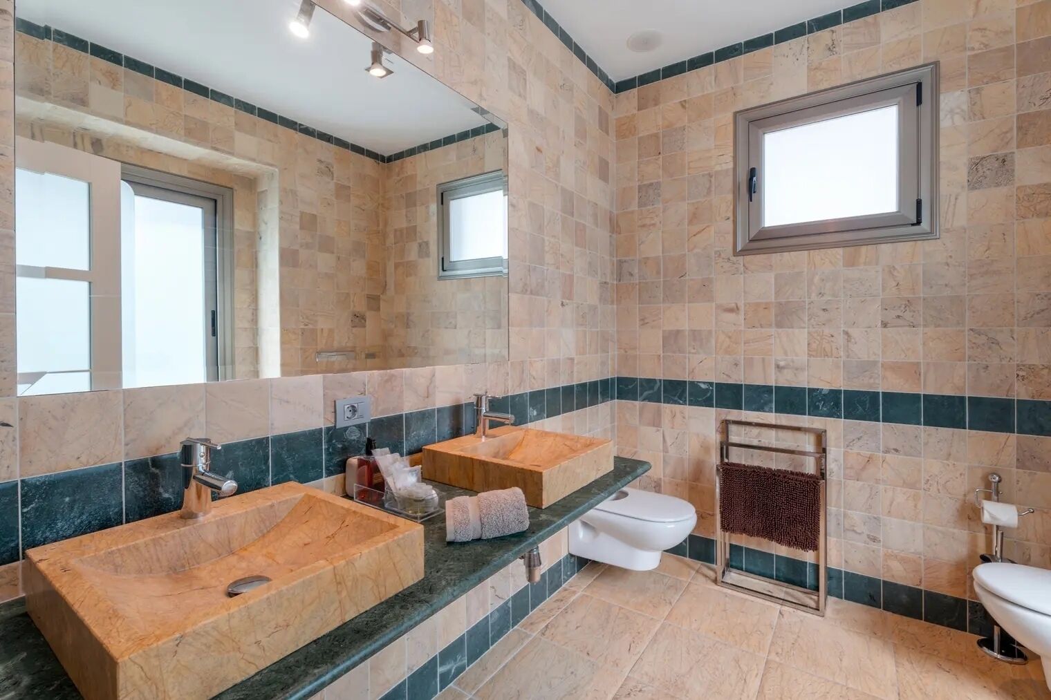 A bathroom with a large wooden vanity, a white toilet, and a towel rack.